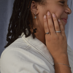 Close-up of sterling silver heart hoop earrings being worn